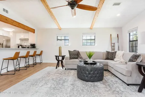 a living room with furniture a flat screen tv and a large window