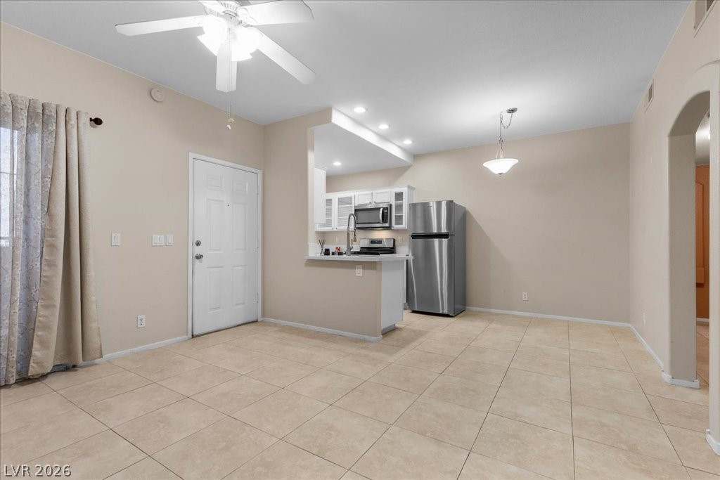 2201 Ramsgate Drive, Unit 818 Henderson, NV 89074 - Photo 7 of 32 Kitchen featuring a peninsula, glass fronted cabinets, stainless steel appliances, white cabinets, and a ceiling fan