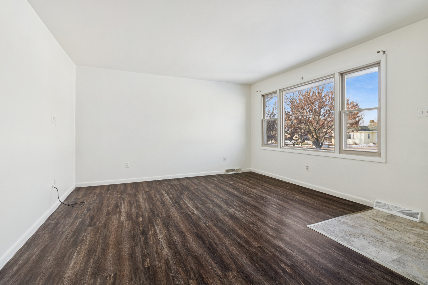 2420 Pecan Street Joliet, IL 60435 - Photo 5 of 20 an empty room with wooden floor and windows