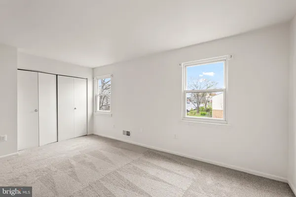 an empty room with windows and closet