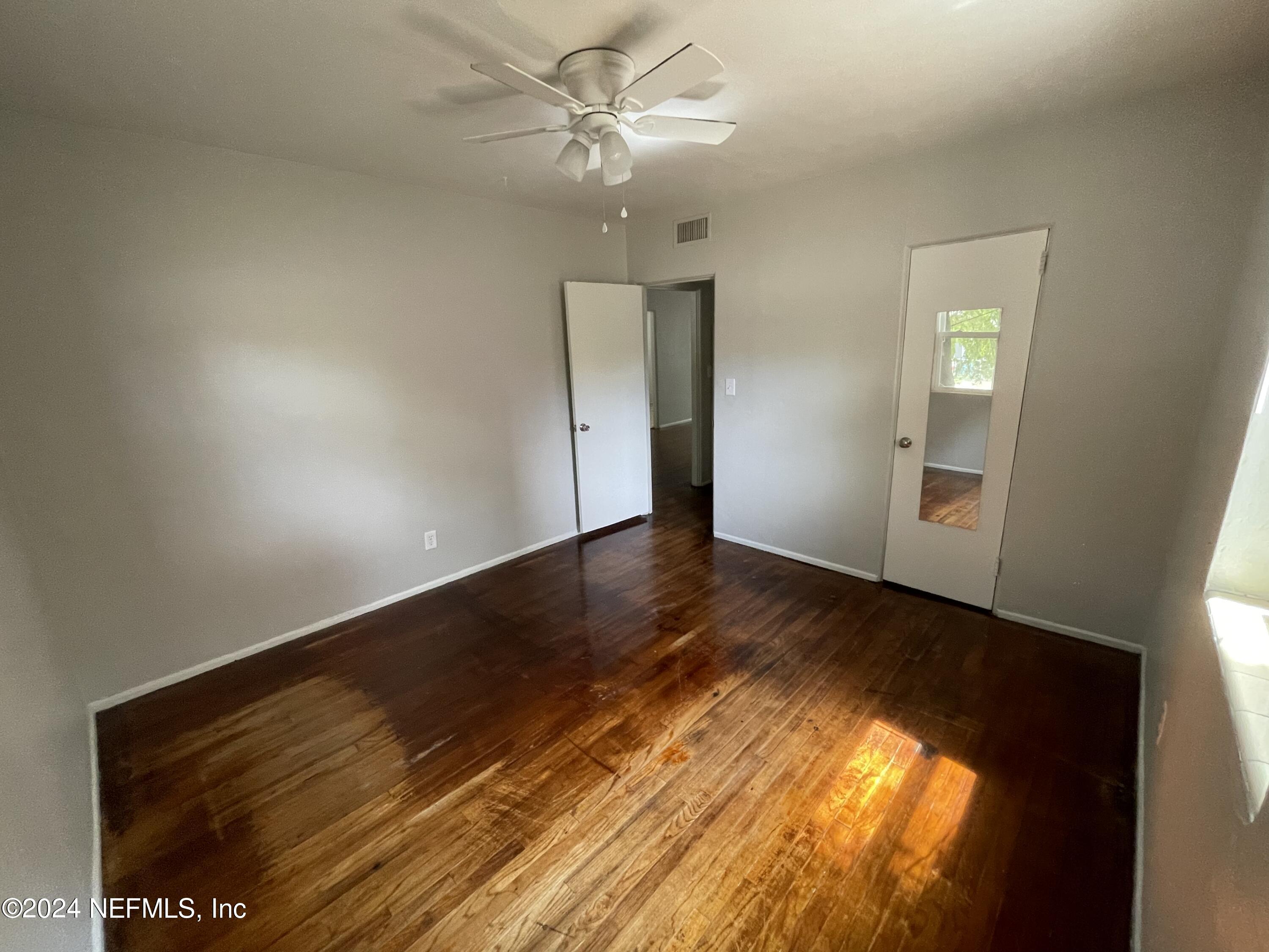 2117 Spring Park Road, Unit 2 Jacksonville, FL 32207 - Photo 7 of 9 a view of an empty room with wooden floor and a ceiling fan
