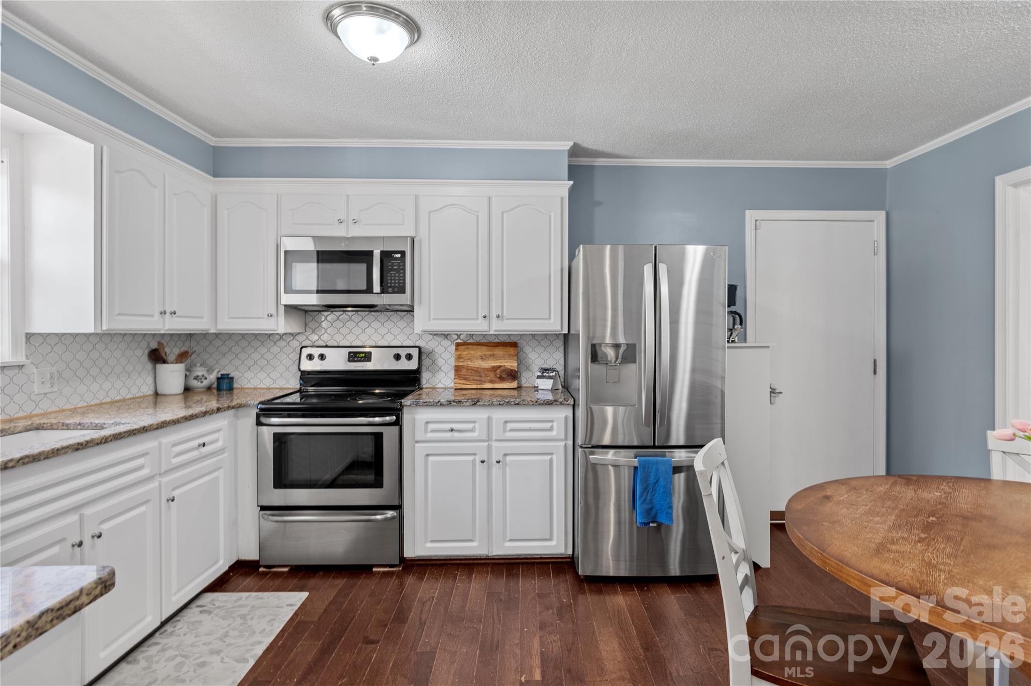 778 Reynolds Road Lewisville, NC 27023 - Photo 12 of 33 a kitchen with a refrigerator stove and wooden cabinets
