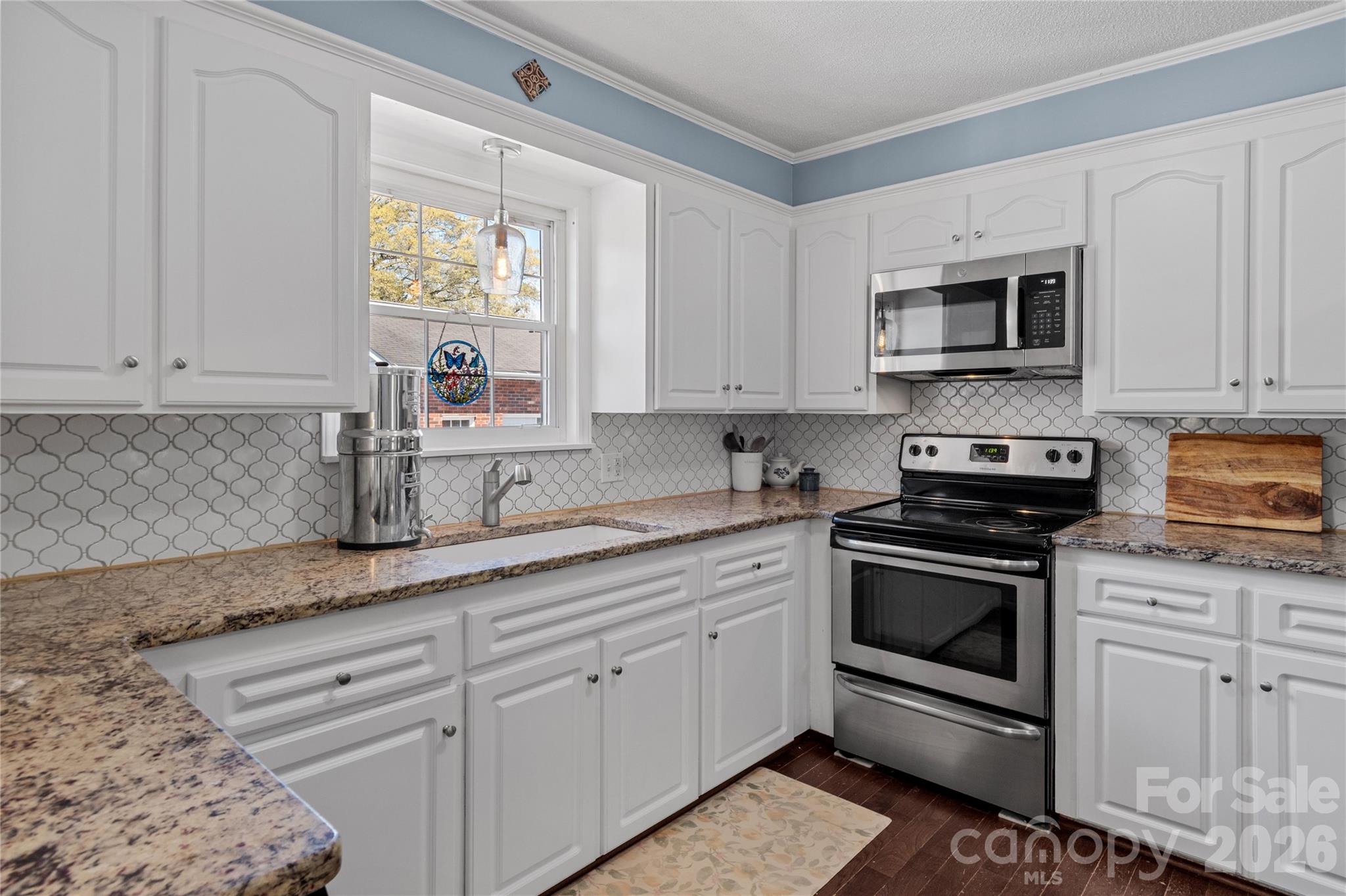 778 Reynolds Road Lewisville, NC 27023 - Photo 13 of 33 a kitchen with granite countertop white cabinets stainless steel appliances and a window