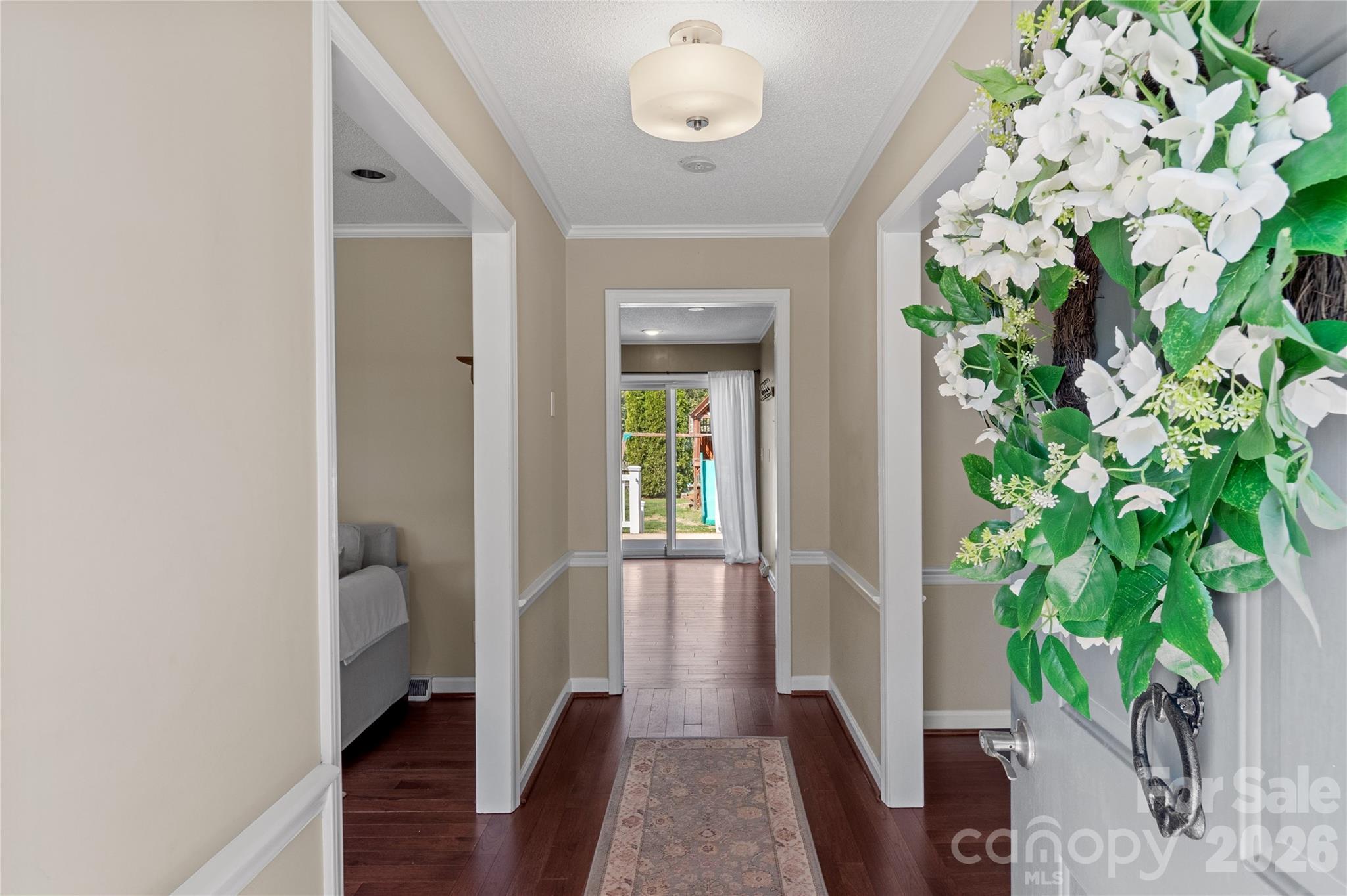 778 Reynolds Road Lewisville, NC 27023 - Photo 7 of 33 a view of a hallway with wooden floor and a potted plant