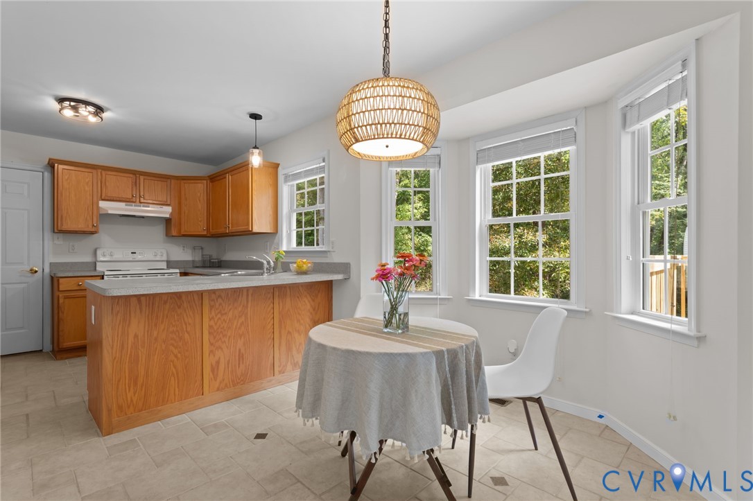 5211 Alberta Road Chesterfield, VA 23832 - Photo 12 of 43 a kitchen with stainless steel appliances granite countertop a sink a stove a refrigerator with a dining table and chairs