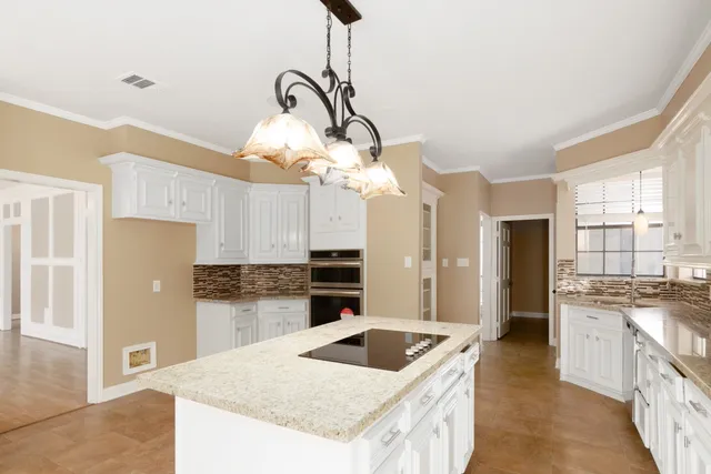 a kitchen with a sink a stove and cabinets