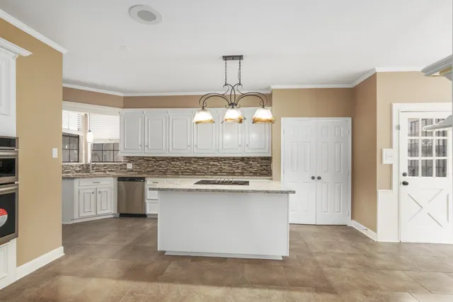 a kitchen with kitchen island granite countertop a sink stove and refrigerator