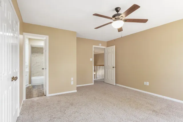 a view of an empty room and a ceiling fan