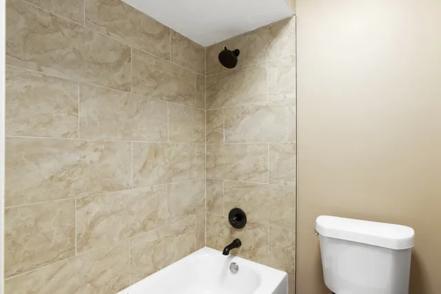 a bathroom with a toilet and a shower