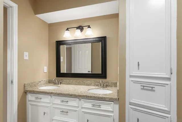 a bathroom with a granite countertop sink and a mirror