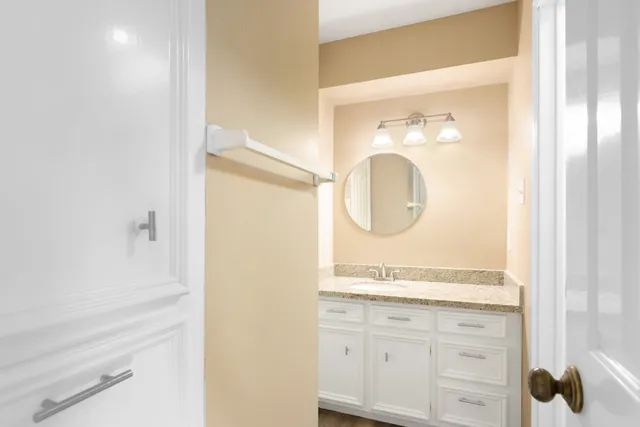 a bathroom with a granite countertop sink and a mirror