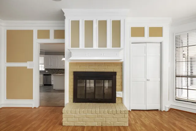 a view of a livingroom with wooden floor and a fireplace