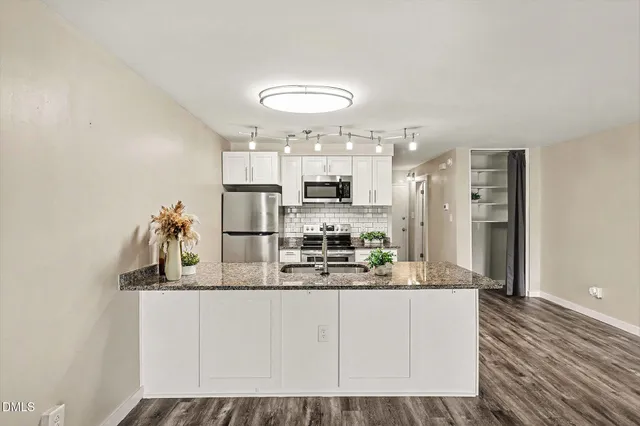 a kitchen with stainless steel appliances granite countertop a stove a sink and a refrigerator