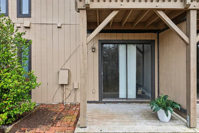 a view of a yard with plants and brick wall