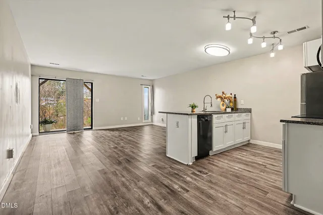 a kitchen with granite countertop a sink cabinets and wooden floor