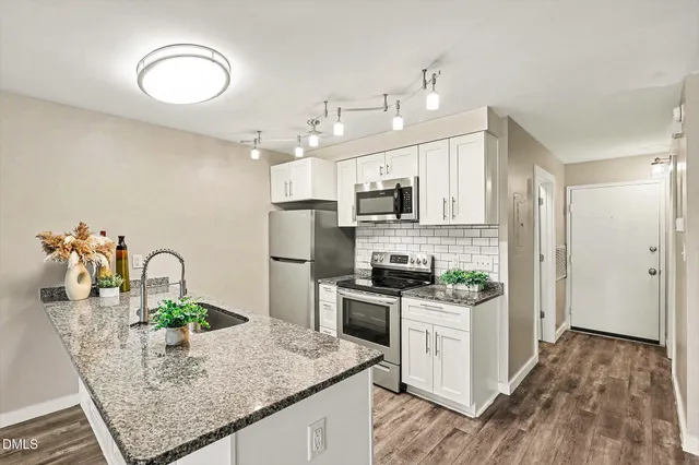 a view of a kitchen with furniture and wooden floor