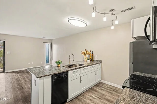 a kitchen with stainless steel appliances granite countertop a sink and a stove