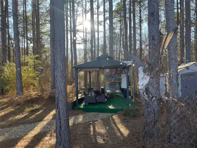 a view of a room with a yard and table and chairs under an umbrella