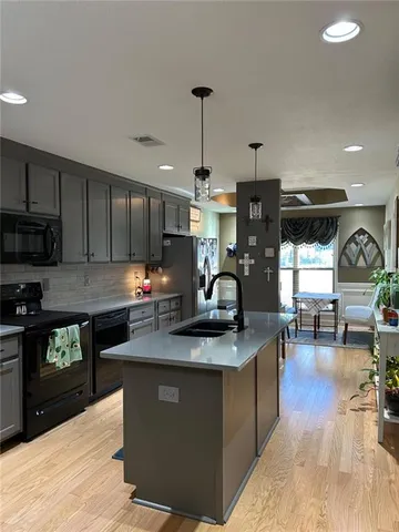 a kitchen with stainless steel appliances granite countertop a sink a stove top oven a counter space and cabinets