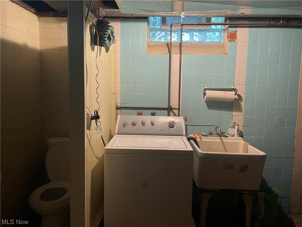 3835 Covington Road Cleveland, OH 44121 - Photo 23 of 34 Clothes washing area with sink, washer / clothes dryer, and tile walls