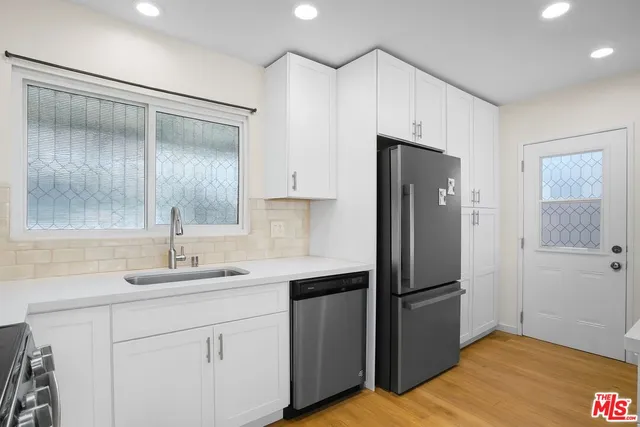 a kitchen with a refrigerator sink and cabinets