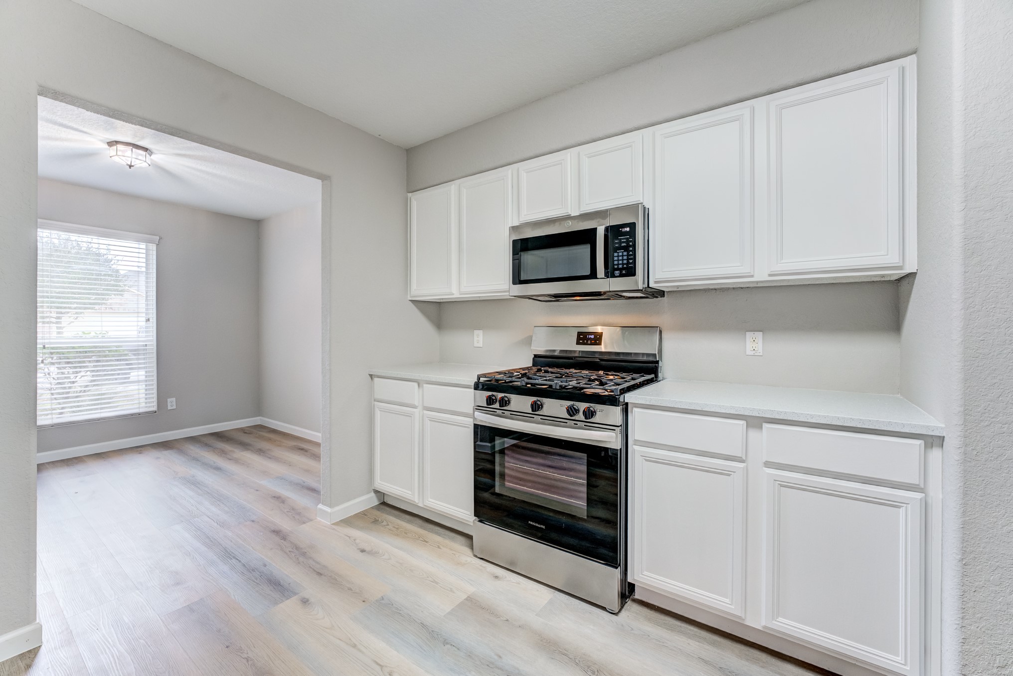 8038 Narrow Brook Way Houston, TX 77016 - Photo 14 of 50 a kitchen with white cabinets and stainless steel appliances