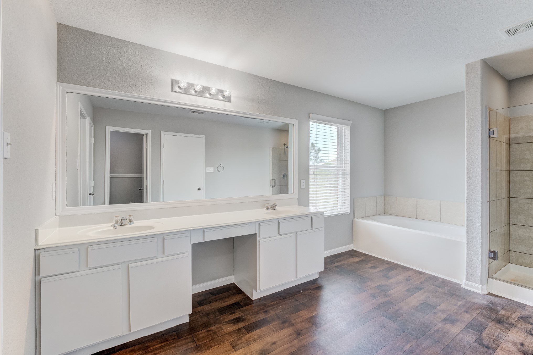 8038 Narrow Brook Way Houston, TX 77016 - Photo 38 of 50 a bathroom with a sink a large mirror and a bathtub