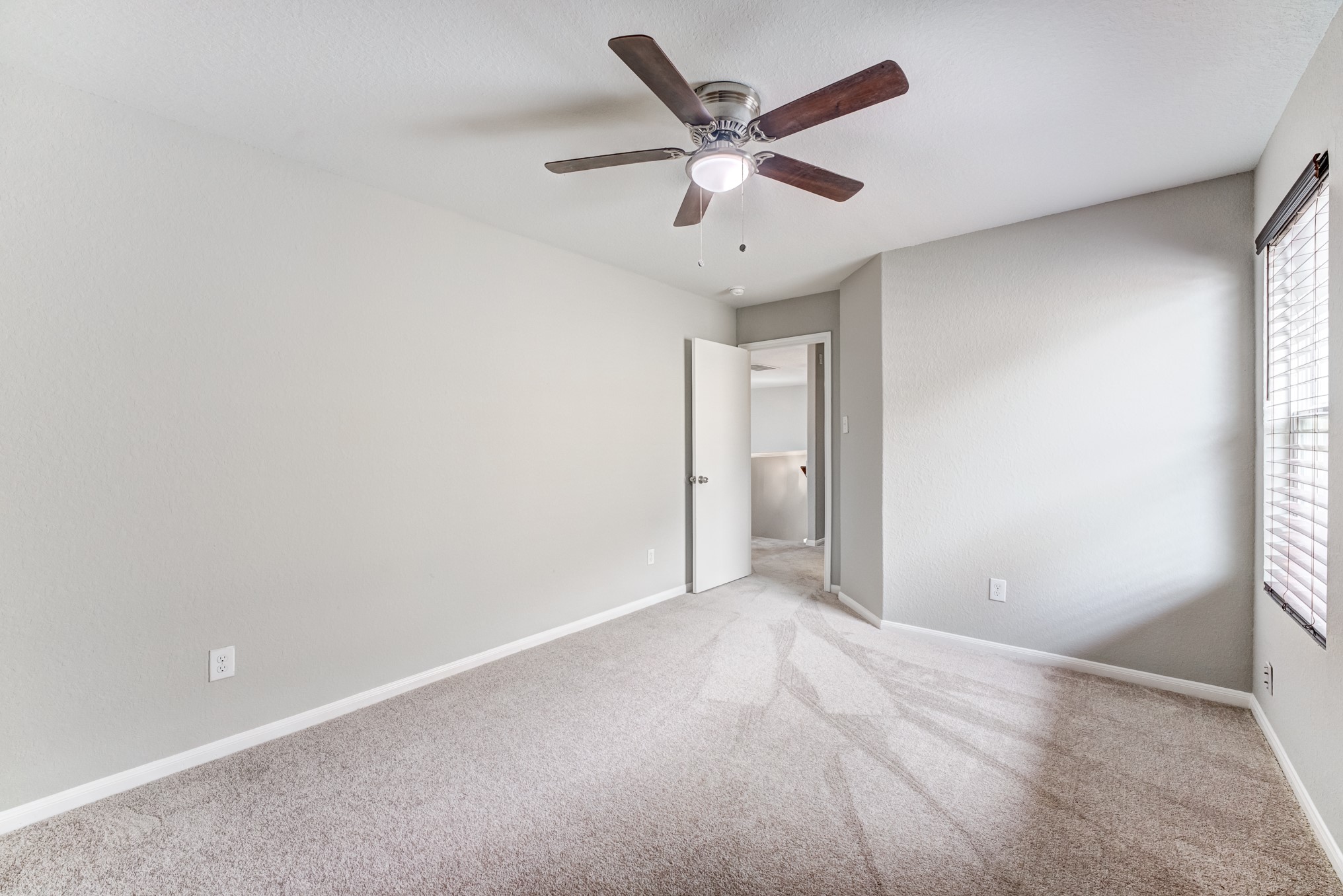 8038 Narrow Brook Way Houston, TX 77016 - Photo 42 of 50 an empty room with ceiling fan and windows