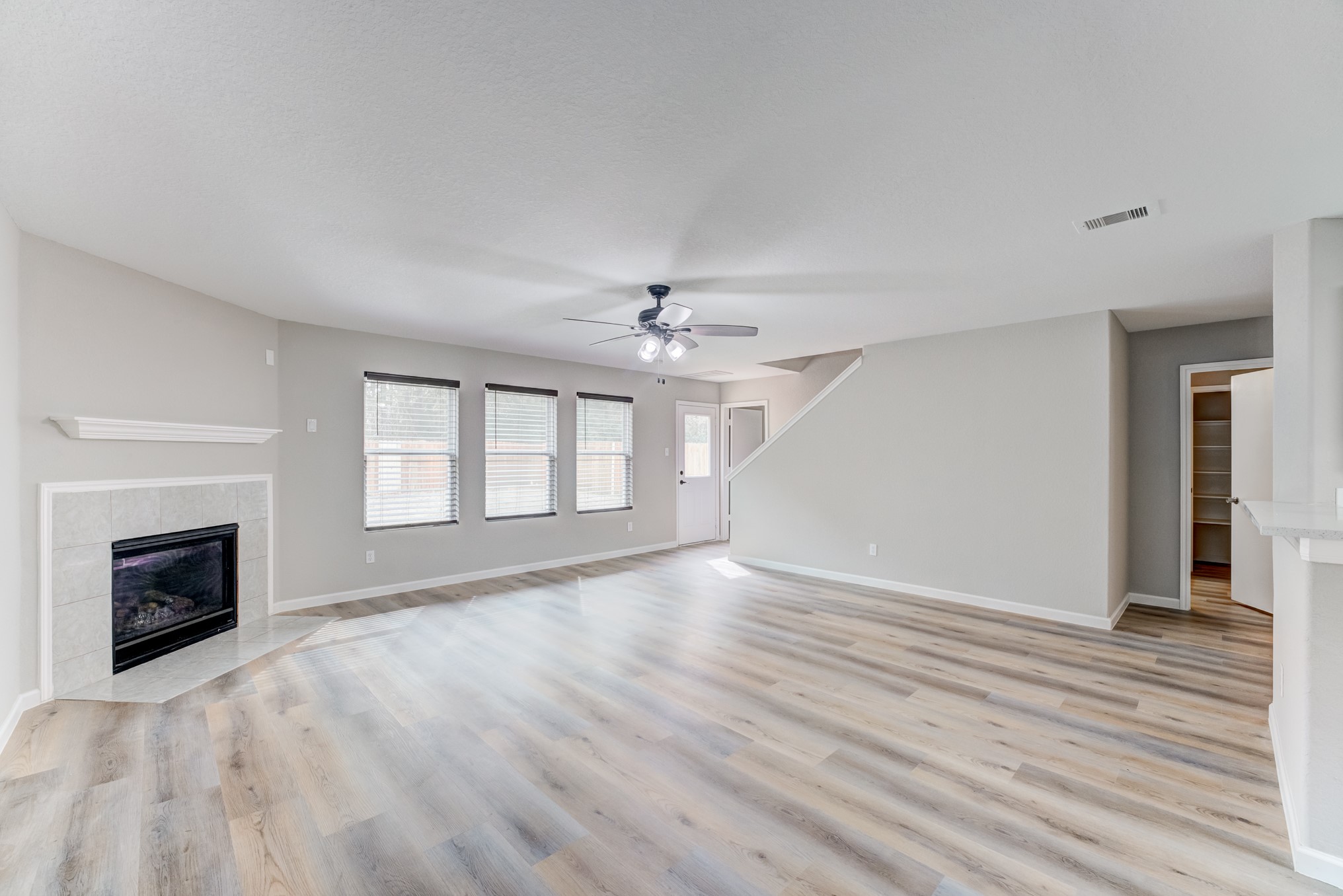 8038 Narrow Brook Way Houston, TX 77016 - Photo 6 of 50 an empty room with wooden floor fireplace and windows