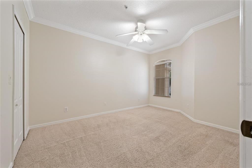 5957 Strada Capri Way Orlando, FL 32835 - Photo 15 of 20 an empty room with a chandelier fan and windows