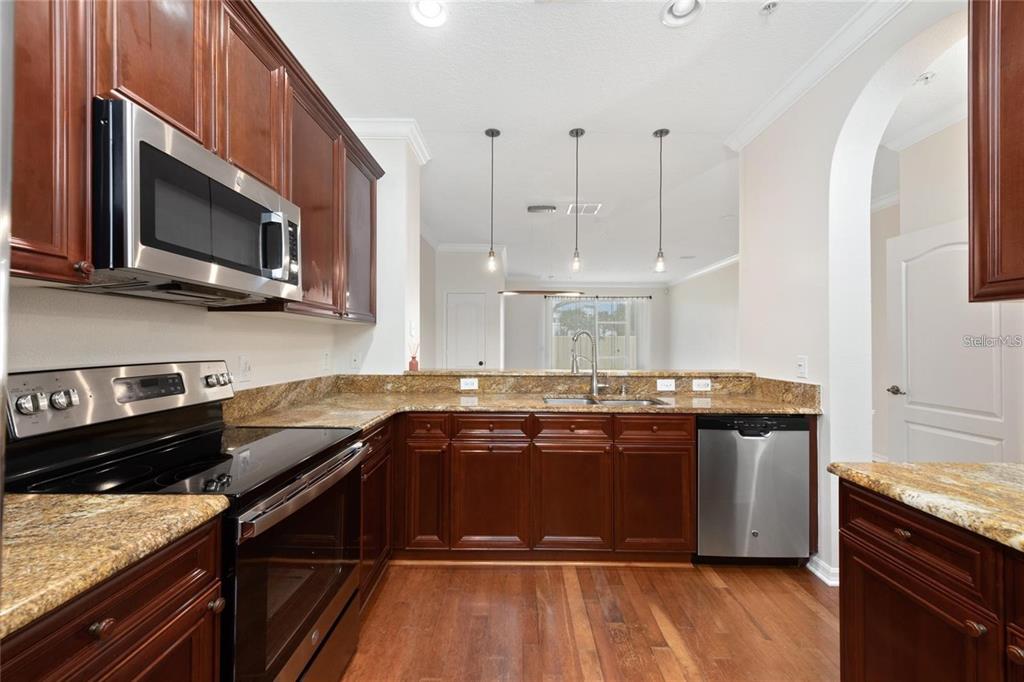5957 Strada Capri Way Orlando, FL 32835 - Photo 4 of 20 a kitchen with a sink stove and microwave