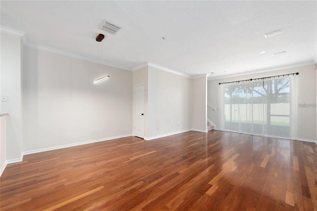 5957 Strada Capri Way Orlando, FL 32835 - Photo 5 of 20 an empty room with wooden floor and windows