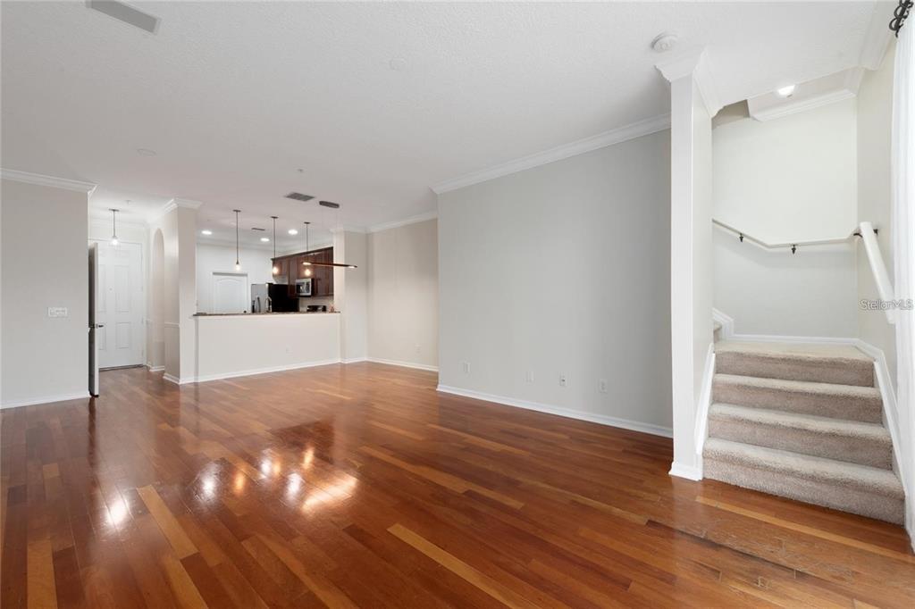 5957 Strada Capri Way Orlando, FL 32835 - Photo 8 of 20 a view of an empty room with wooden floor and a kitchen