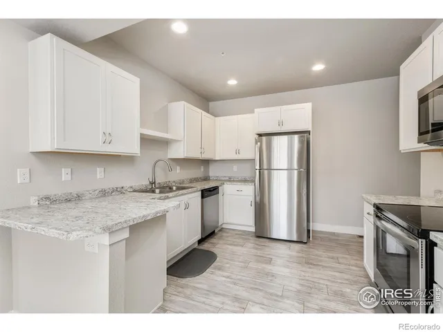 a kitchen with a refrigerator sink and cabinets