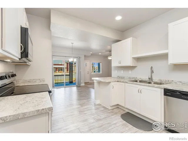 a kitchen with granite countertop a sink stainless steel appliances and cabinets