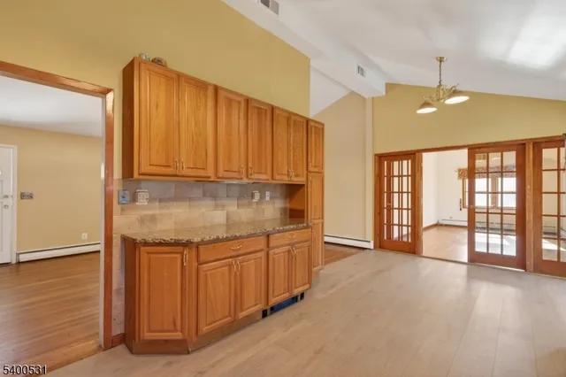 a kitchen with stainless steel appliances granite countertop a stove a sink and a refrigerator with wooden floor