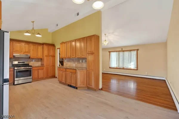 a kitchen with a refrigerator and a stove top oven