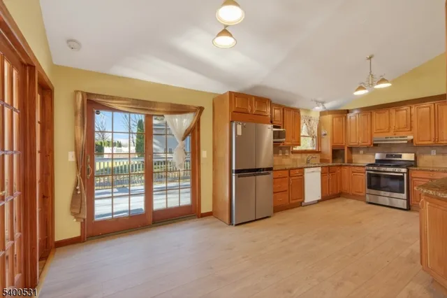 a kitchen with stainless steel appliances a refrigerator sink and cabinets