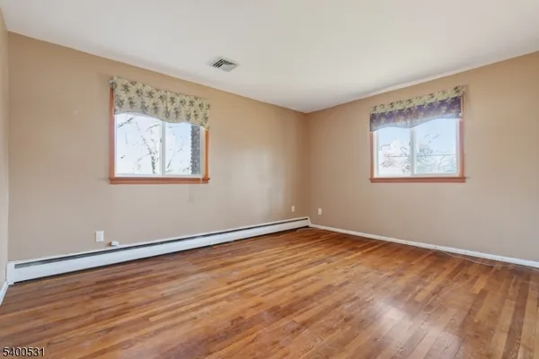 a view of an empty room with wooden floor