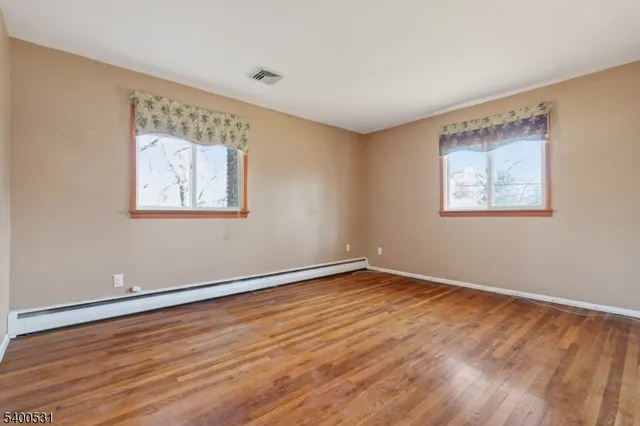a view of an empty room with wooden floor