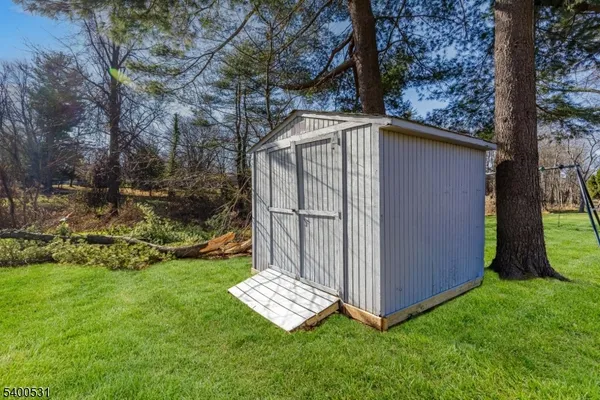 a view of backyard with barn and a large tree