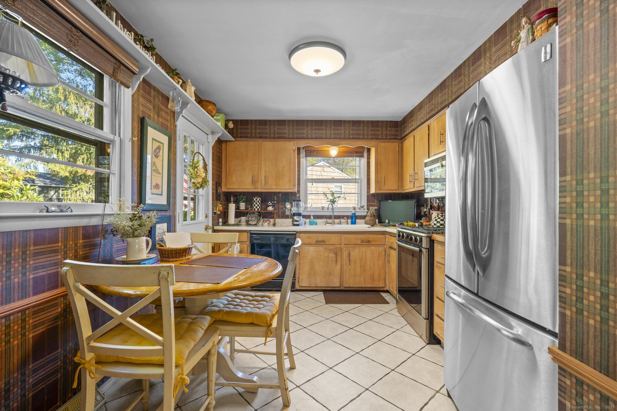 23 Meadow Brook Road West Haven, CT 06516 - Photo 20 of 39 a kitchen with a refrigerator a stove and a dining table with wooden floor