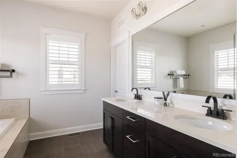 a bathroom with double vanity sink a mirror and a window