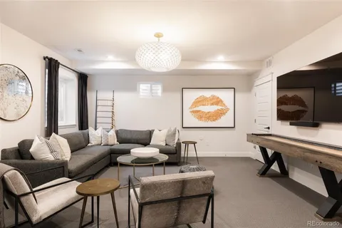 a living room with furniture a flat screen tv and a large window