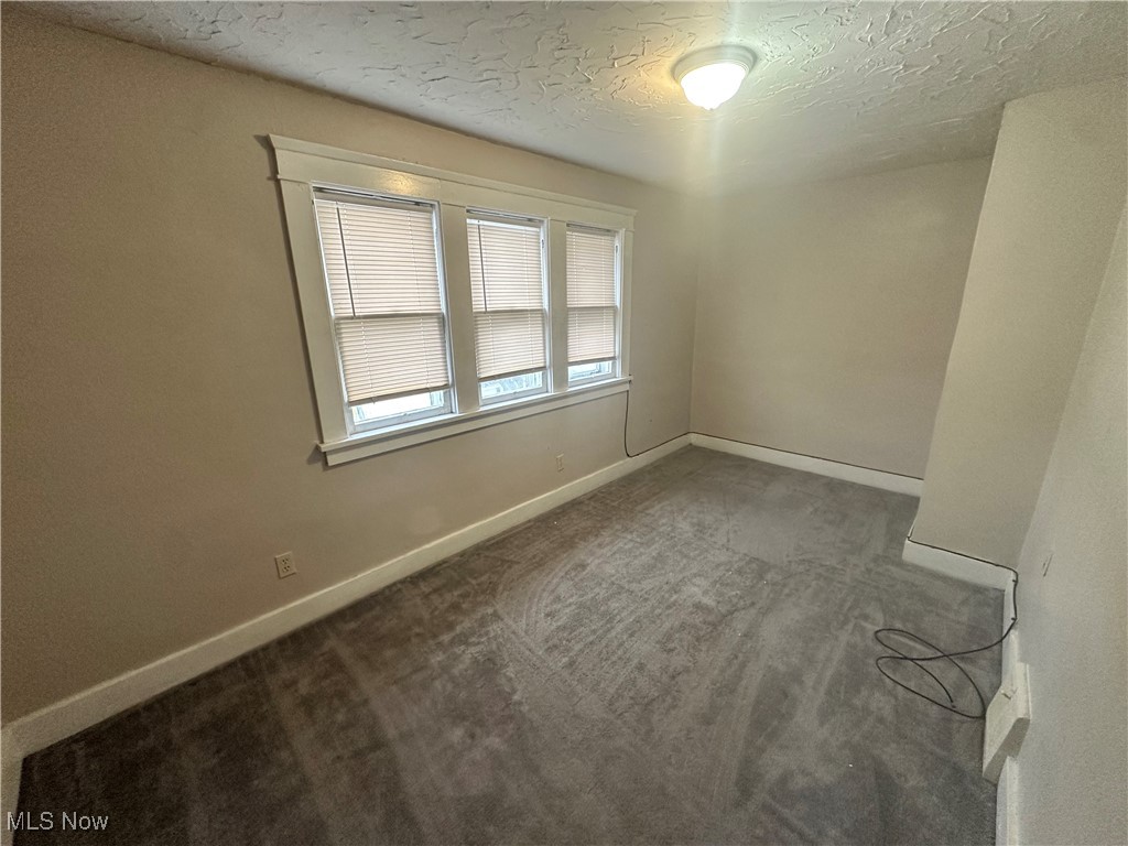 4658 Rockwood Road Cleveland, OH 44125 - Photo 11 of 18 Carpeted spare room featuring baseboards and a textured ceiling