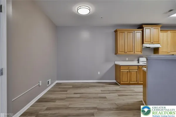 a kitchen with granite countertop a sink cabinets and wooden floor