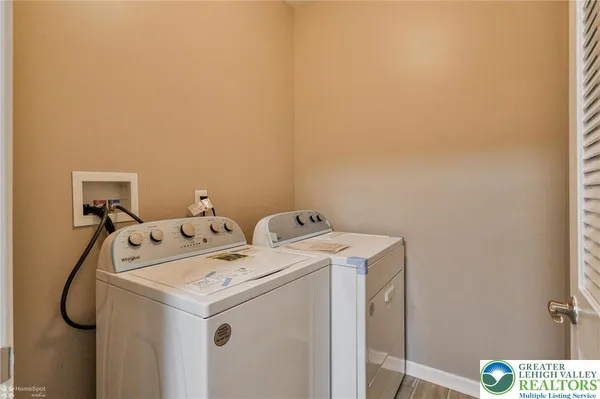 a view of an empty room with wooden floor and a fireplace