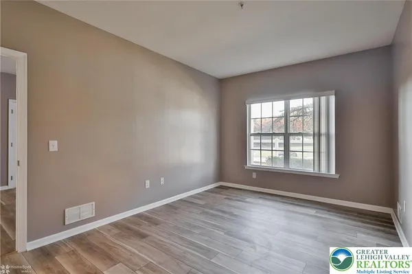 a view of an empty room with wooden floor