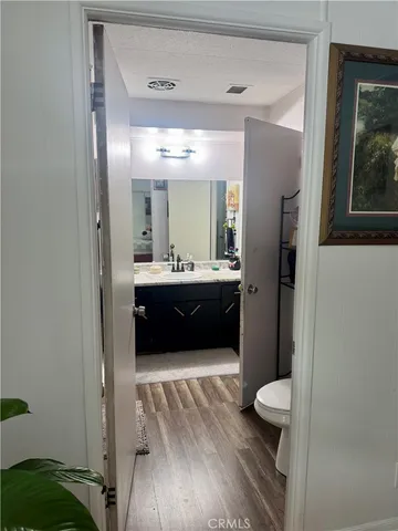 a bathroom with a sink a mirror and painting on the wall