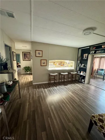a dining room with wooden floor and chandelier